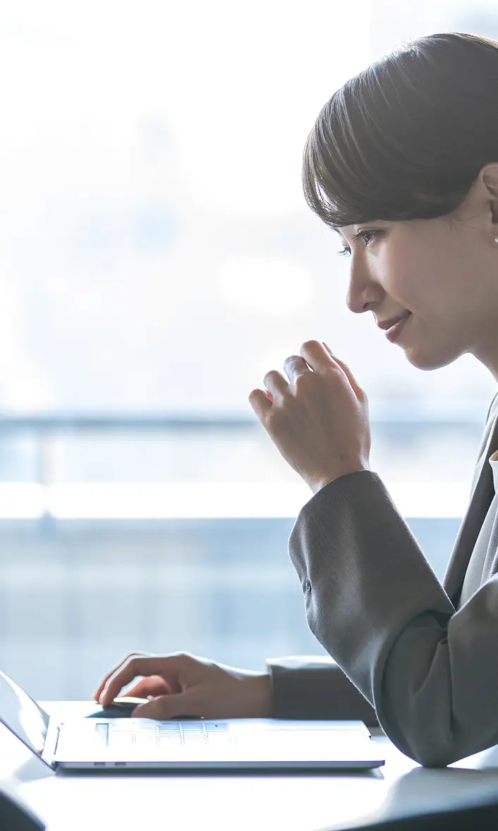 ノートパソコンを操作している女性の横顔の写真